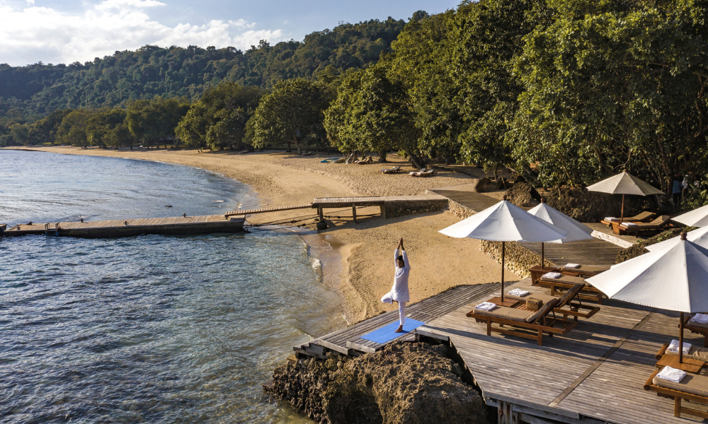 Banner displaying the phrase 'Sculpt, Stretch & Shine' with a serene beach and wooden deck in the background.